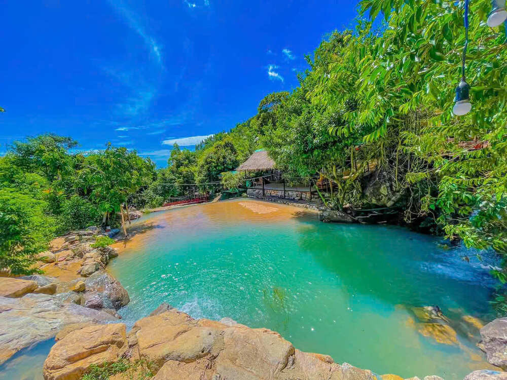 Khung cảnh hồ nước xanh ngắt và những vách đá bao quanh tại Tuyệt Tình Cốc, minh họa cho vẻ đẹp độc đáo của địa điểm