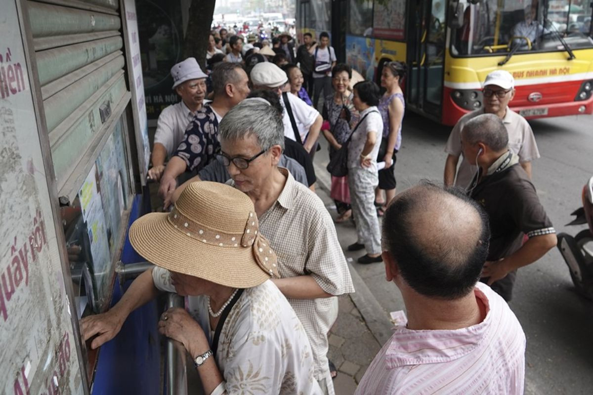 Người cao tuổi nộp hồ sơ đăng ký thẻ xe buýt miễn phí tại quầy dịch vụ.