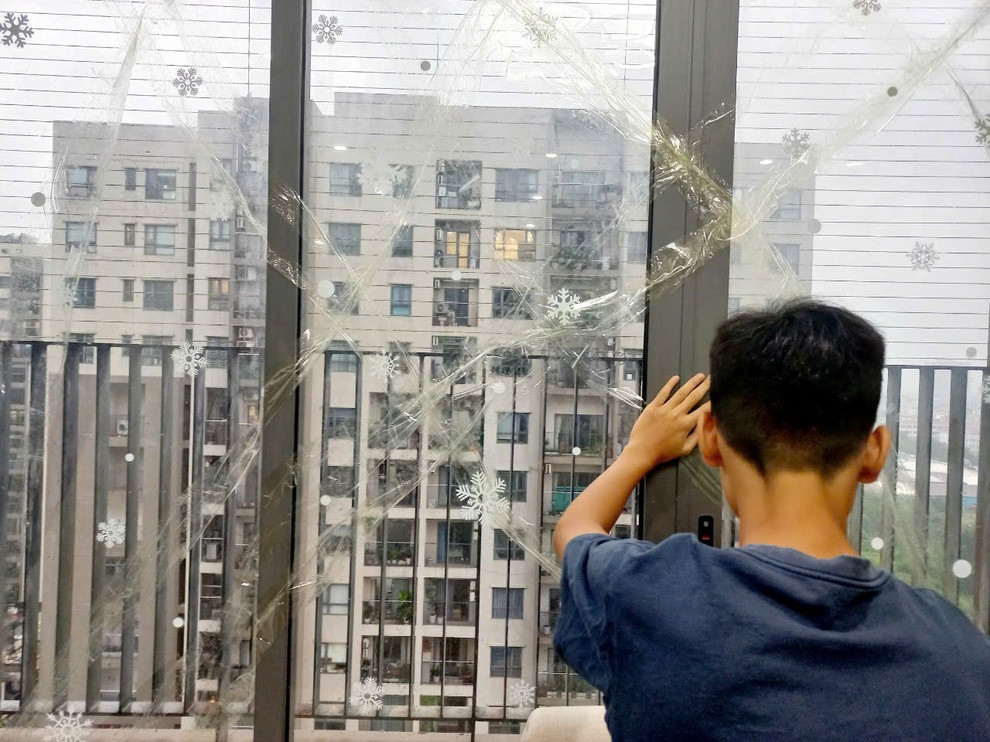 Hình ảnh người dân chung cư Nam Từ Liêm dán băng dính lên cửa kính để chống bão mạnh