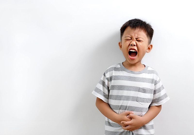 Một em bé đang ôm bụng, thể hiện dấu hiệu khó tiêu, cần được khám dinh dưỡng cho bé sớm