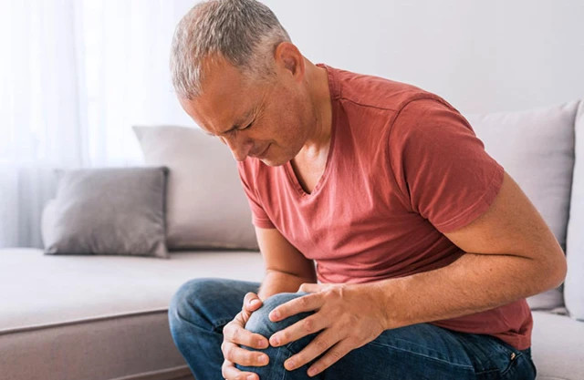 Người bị đau đầu gối, thể hiện triệu chứng thỉnh thoảng bị đau nhói ở đầu gối, cần tìm hiểu nguyên nhân và cách điều trị hiệu quả.