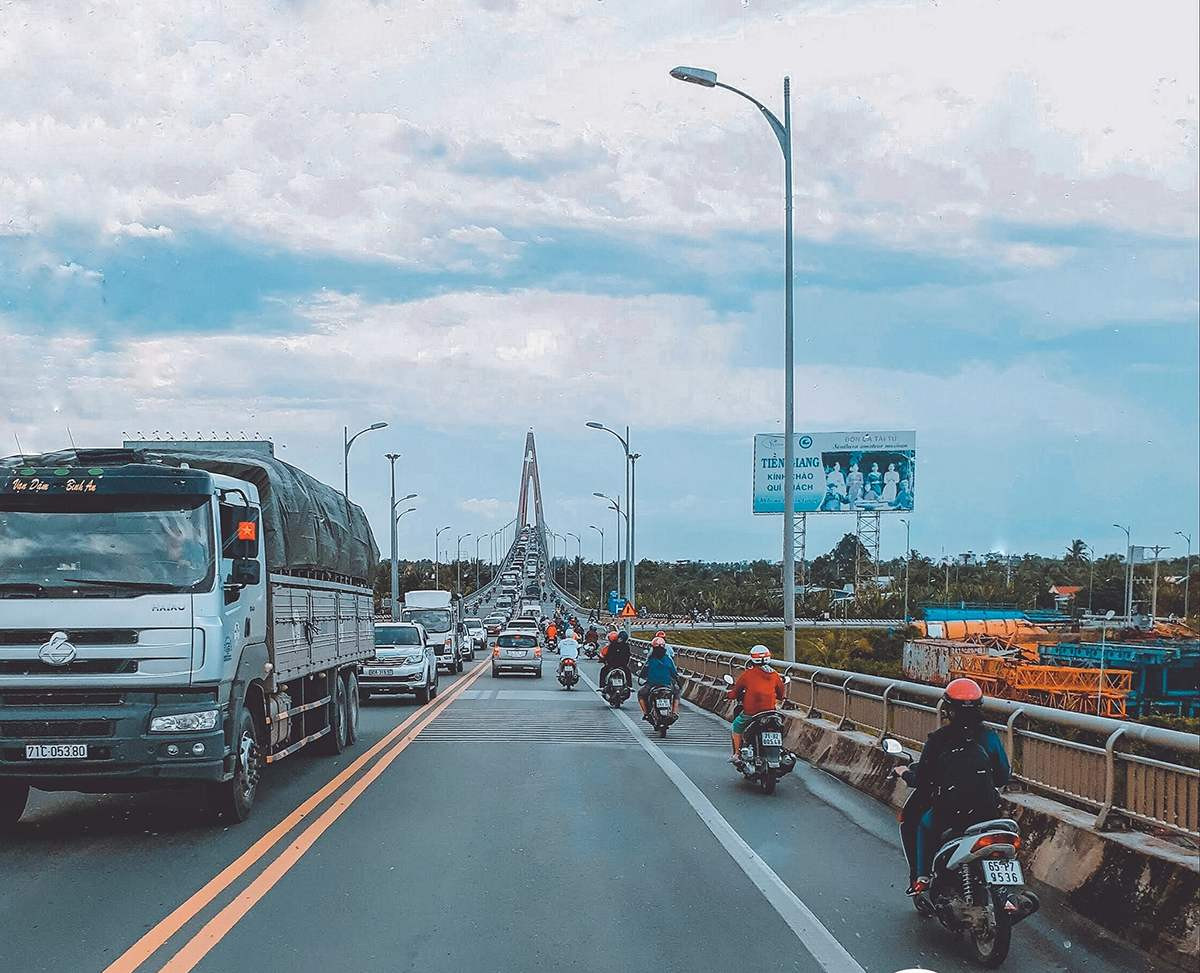 Người lái xe máy di chuyển trên tuyến đường quốc lộ từ TP.HCM đến Tiền Giang, minh họa quãng đường và phương tiện di chuyển.