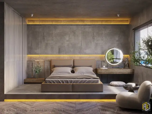 Một Phòng Ngủ Hiện Đại, Giường Ngủ Thấp Đặt Trên Bục Cao, Bức Tường Xi Măng Mộc Mạc Làm Nổi Bật Chiếc Gương Trang Điểm Có Đèn Viền Và Không Gian Thư Giãn Cạnh Cửa Sổ