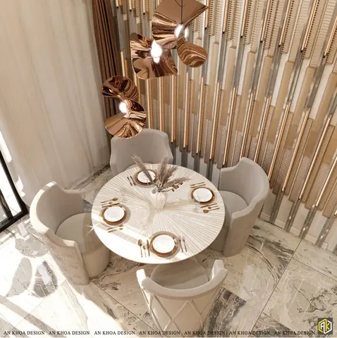 Không Gian Ăn Uống Sang Trọng, Ấm Cúng Với Bàn Tròn Mặt Đá Trắng Vân Tinh Tế Và Ghế Nhung Mềm Mại, Nổi Bật Với Đèn Thả Xoắn Ốc Màu Đồng Và Tường Ốp Gỗ Trang Trí Ấn Tượng