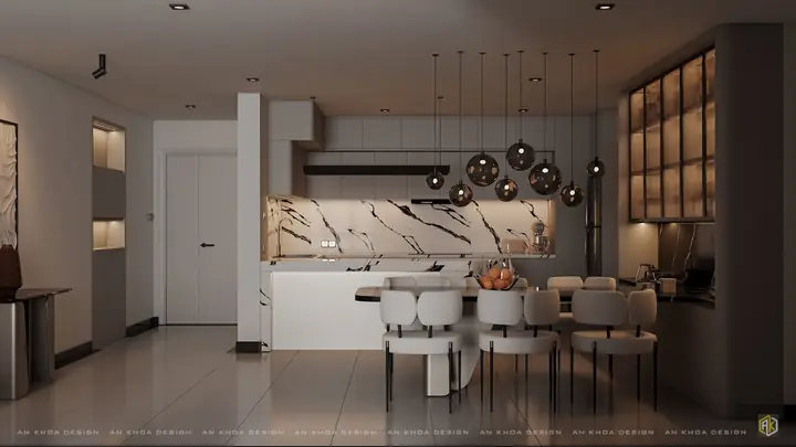 Không Gian Bếp Hiện Đại Với Điểm Nhấn Là Mặt Đá Vân Mây Sang Trọng Và Hệ Đèn Thả Ánh Vàng Tạo Chiều Sâu Ấm Cúng; Bàn Ăn Liền Kề Mang Lại Sự Kết Nối Hài Hòa Và Tiện Nghi
